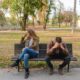 woman and man sitting on brown wooden bench